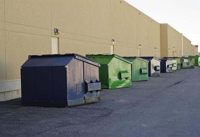 a construction worker moves construction materials near a dumpster in Carriere